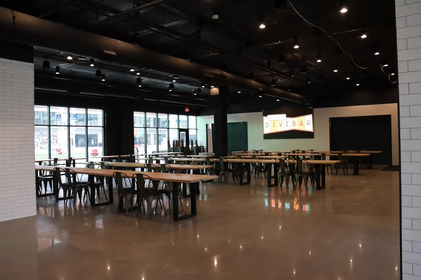The Lights Event Center interior — hall with illuminated venue sign, butcher block tables, and polished concrete floors